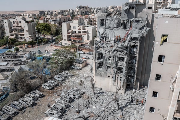 Emergency workers at the site of an Iranian missile attack on a residential building in Beersheba, Israel, on Tuesday, June 24, 2025. Iran launched a deadly strike in Beersheba, and Israel struck targets in Tehran early Tuesday, Israeli officials said, hours before the countries confirmed they had agreed to a cease-fire. (Daniel Berehulak/The New York Times)