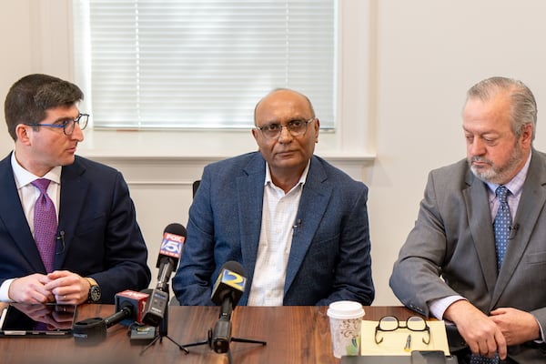 Mahendra Patel, flanked by his attorney,s speaks at a press conference regarding a lawsuit filed in response to his March 2025 arrest, Monday, Feb. 9, 2026. (Ben Hendren for the AJC)