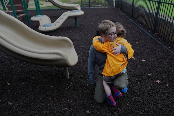 Kirt Ethridge hugs his daughter, Eliza, 5, while at a playground Thursday, April 10, 2025, in Evansville, Ind. (AP Photo/Joshua A. Bickel)