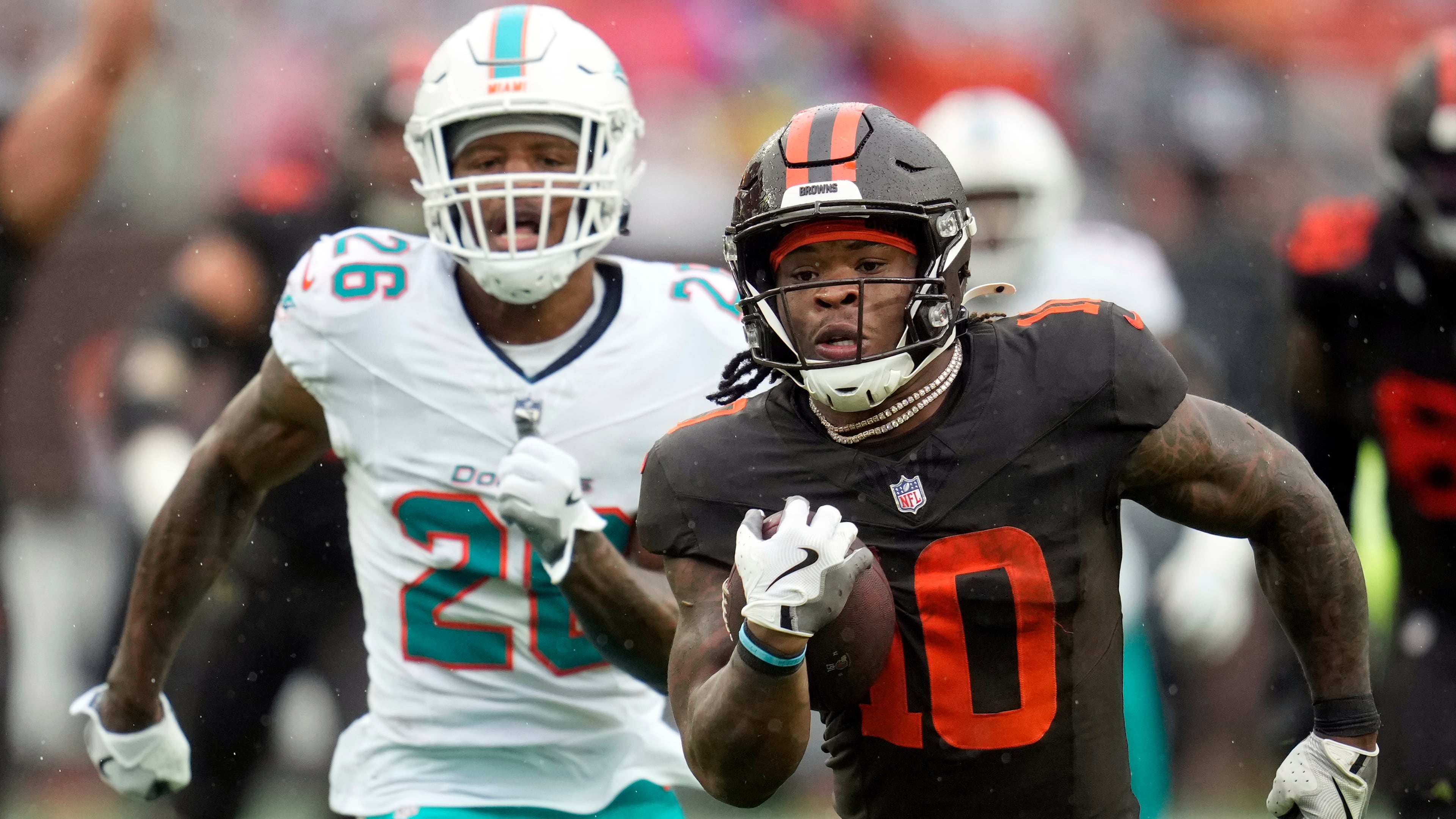 Cleveland Browns running back Quinshon Judkins (10) carries the ball ahead of Miami Dolphins cornerback Rasul Douglas (26) in the first half of an NFL football game in Cleveland, Sunday, Oct. 19, 2025. (AP Photo/Sue Ogrocki)