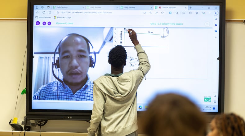 A student writes on a classroom smart board during an 11th grade physics class taught virtually by Bienvenido Oliver at Rockdale Career Academy in Conyers, Georgia, on Sept. 22, 2023. (Arvin Temkar/The Atlanta Journal-Constitution/TNS)