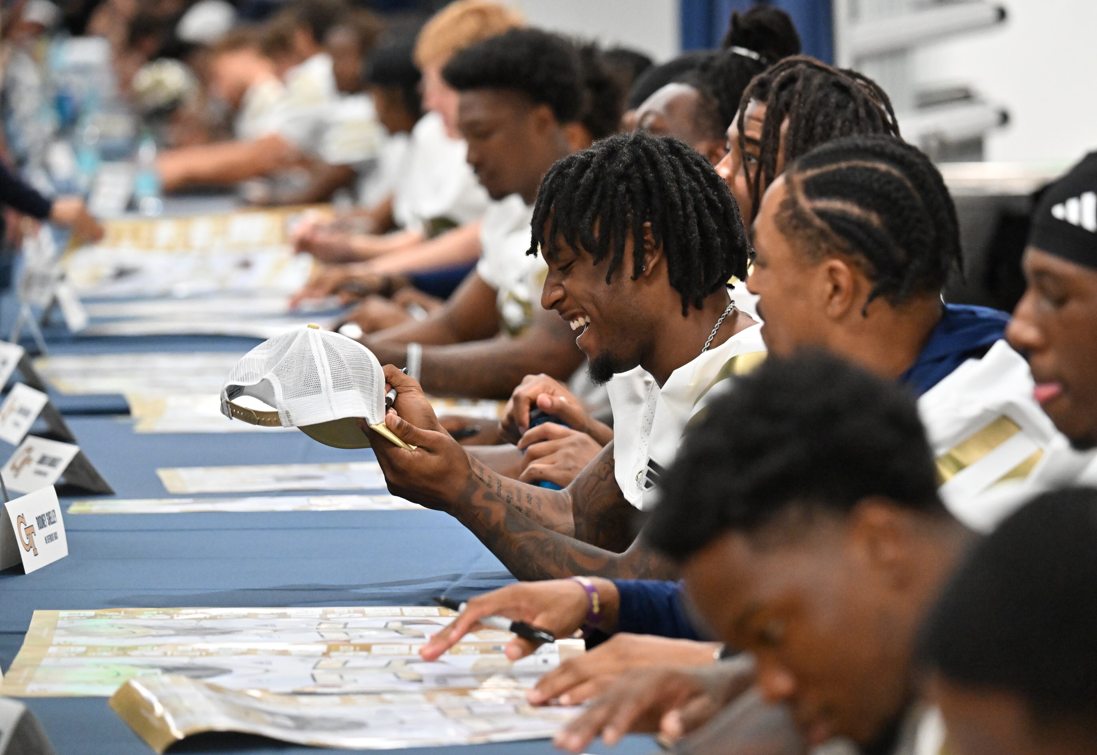Georgia Tech football players sign autographs for event attendees during the annual “First Saturday on The Flats” at Bobby Dodd Stadium, Saturday, August 2, 2025, in Atlanta. The Flats provides Tech fans with the opportunity to engage with their favorite Yellow Jackets ahead of the upcoming 2025 season. The event offers a variety of entertaining activities for the whole family, including a DJ, autograph opportunities, tailgate games and interactive experiences right on the field at Bobby Dodd Stadium. (Hyosub Shin / AJC)