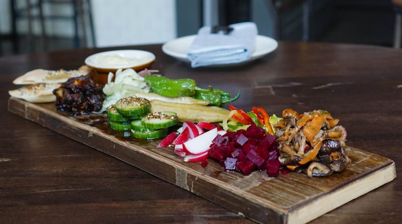 Saltyard’s Veggie Board is an assembly of seasonal raw, pickled and roasted vegetables that will change with the seasons just like the accompanying hummus — currently, field peas are the replacement for traditional chickpeas — and house-made seed crackers. CONTRIBUTED BY SALTYARD