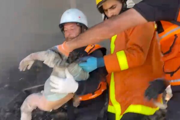 In this frame grab from a video released by Gaza Civil Defense, workers collect the remains a a child after an Israeli strike on a home in Khan Younis killed nine of a doctor's ten children while she was at work, according to Ahmad al-Farra, head of the pediatric department at Nasser Hospital, in Khan Younis, Gaza Strip, Saturday, May 24, 2025. (Gaza Civil Defense via AP)