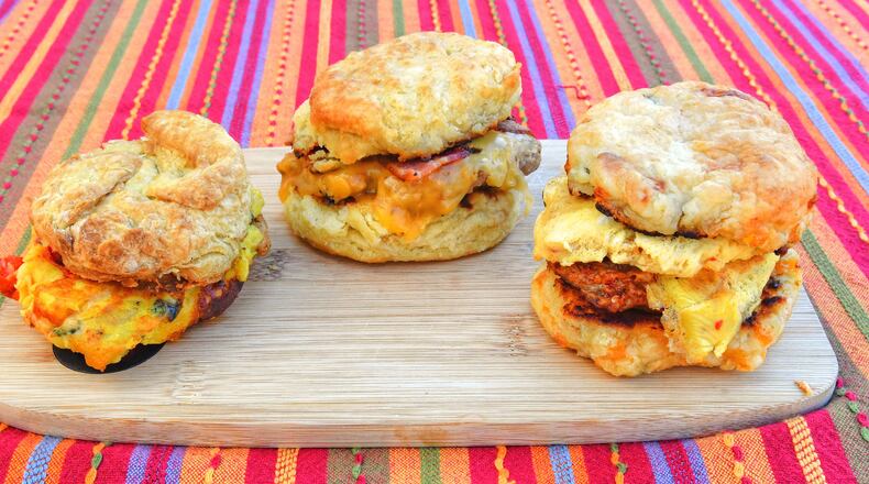 Among the offerings at Bomb Biscuits are (from left) a vegan Florentine biscuit, a Kentucky hot brown biscuit and the Atomic biscuit. Chris Hunt for The Atlanta Journal-Constitution