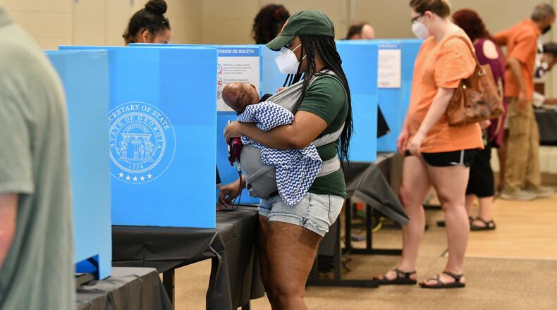 Gwinnett County residents, including Latanya Adams (center) with her 4-month-old son Princeton, cast their votes at the Pinckneyville Community Center in Norcross during the Georgia primary June 9. (Hyosub Shin / Hyosub.Shin@ajc.com)