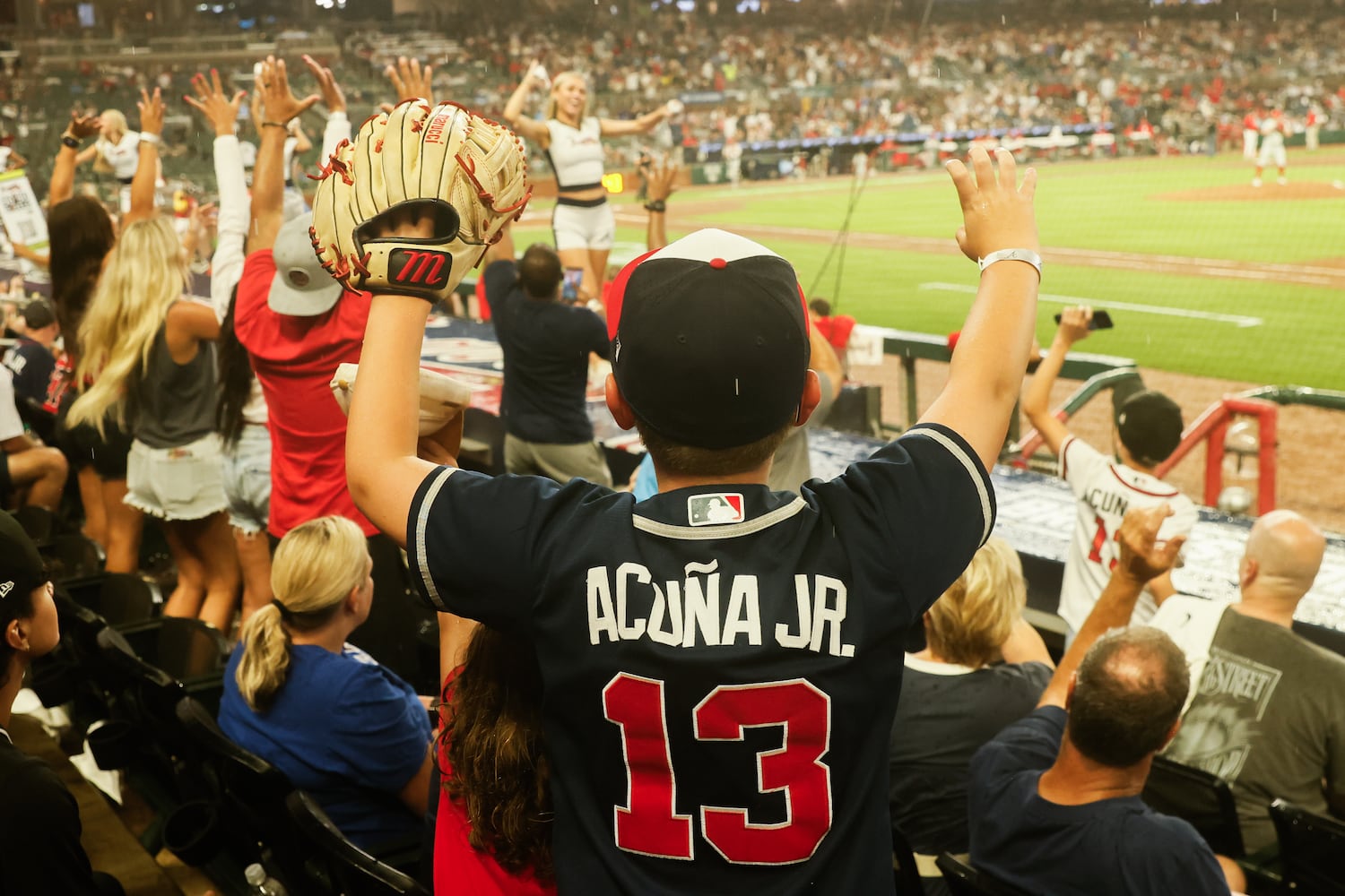 A fan puts his arms up to catch a towel between innings during the Braves game against the Phillies at Truist Park on Friday, June 27, 2025, in Atlanta. (Abbey Cutrer/AJC)