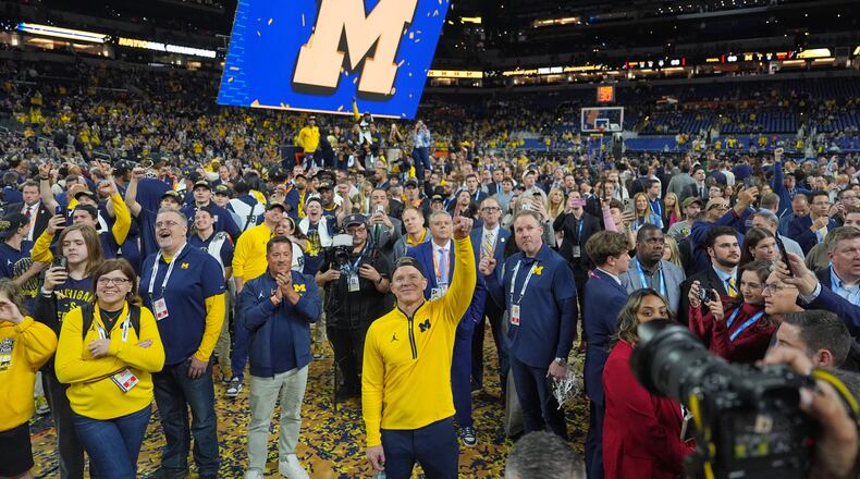 Michigan head coach Dusty May celebrates after defeating UConn in the NCAA college basketball tournament national championship game at the Final Four, Tuesday, April 7, 2026, in Indianapolis. (AP Photo/Michael Conroy)