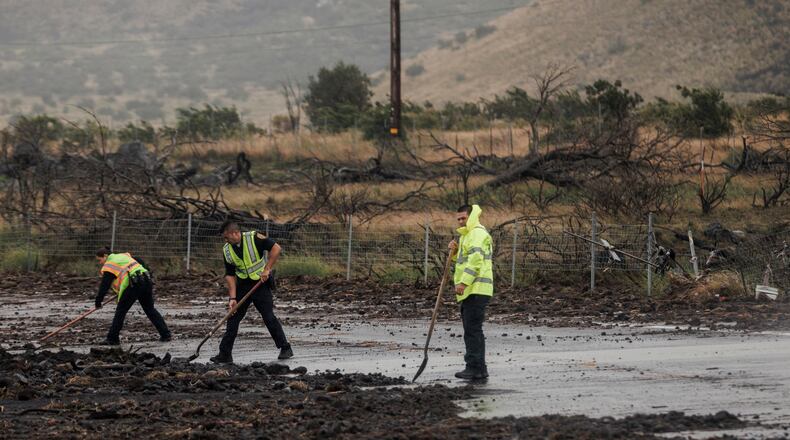 Police remove debris strewn across Daniel K. Inouye Highway by Hurricane Lala near Waimea, Hawaii, Sunday, Aug. 16, 2026. (Stephen Lam/San Francisco Chronicle via AP)