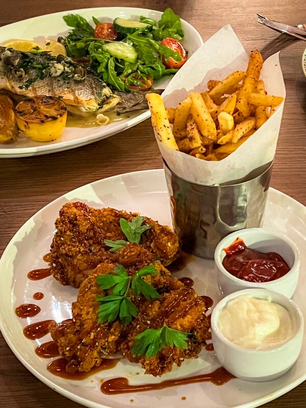 The fried chicken at Bey Mediterranean Kitchen & Bar is a wonder of flavor and texture, thanks to its thick, heavily spiced breading. (Henri Hollis/AJC)
