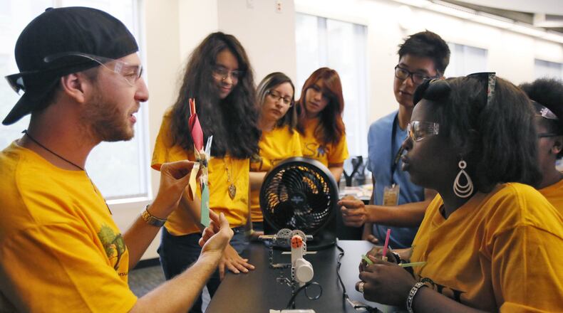 Cameron Schriner (left), assistant program coordinator, tests the efficiency of wind mills the students have made by measuring the electric current they generate at a Georgia Tech summer camp held in 2014 in science, technology, math and engineering primarily for Hispanic students. BOB ANDRES / BANDRES@AJC.COM