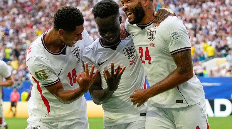 England's Bukayo Saka (7) is congratulated by Jude Bellingham (10) and Reece James (24) after scoring his side's 5th goal from the penalty spot during the World Cup third-place playoff soccer match between France and England in Miami Gardens, Fla., Saturday, July 18, 2026. (AP Photo/Lynne Sladky)