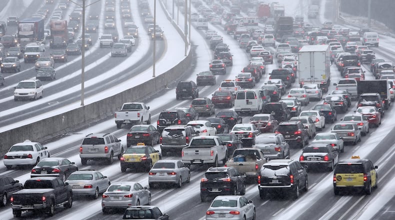 Traffic inched along the Downtown Connector as snow fell across the Atlanta region Jan. 28, 2014. BEN GRAY / BGRAY@AJC.COM