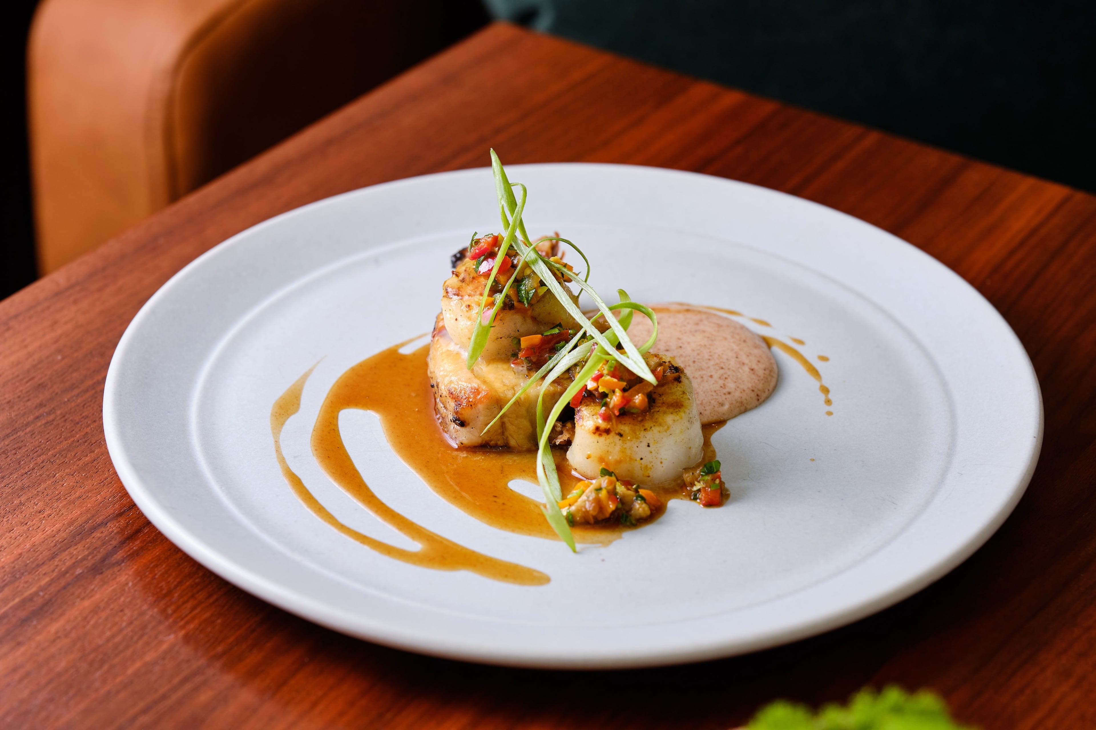 At Nàdair, nearly every dish touches the restaurant's Demant-made grill, like this scallop and pork belly with cornbread puree and warm pepper relish. (Courtesy of Brandon Amato/Nàdair)
