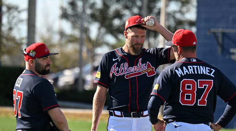 Braves pitcher Chris Sale (center) confers with pitching coach J.P. Martinez (right) during the second day of pitchers and catchers workouts Wednesday, Feb. 11, 2026, at CoolToday Park in North Port, Fla. (Hyosub Shin/AJC)