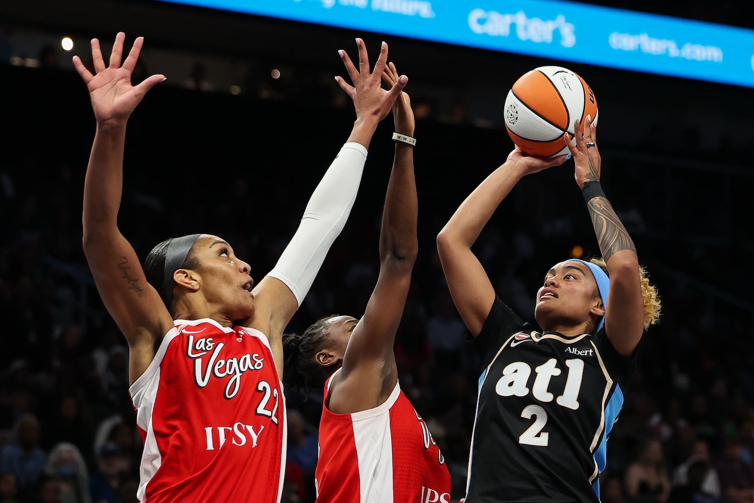 Dream guard Te-Hina Paopao (right) shots against Aces center A'ja Wilson (left) during the first half Sunday, May 17, 2026, at State Farm Arena in Atlanta. (Colin Hubbard for the AJC) 


