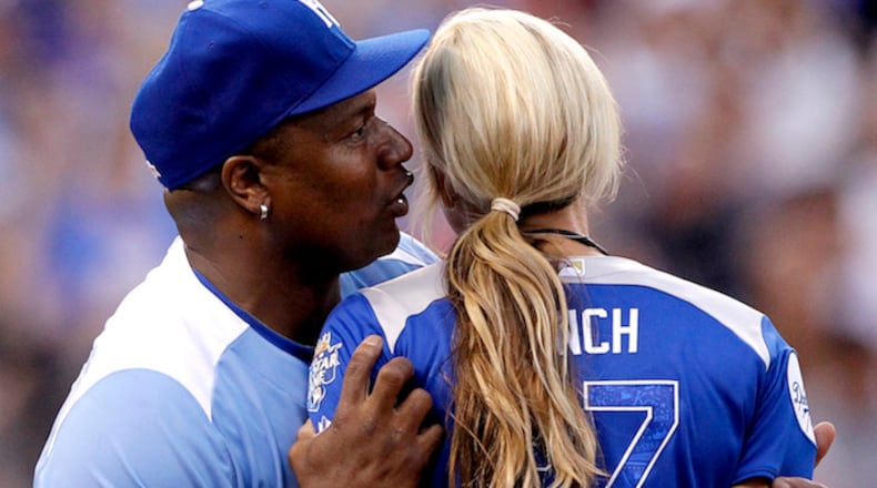 Former NFL and baseball star Bo Jackson whispers into the ear of Jennie Finch, former United States National Softball team pitcher, during the All-Star Legends & Celebrity Softball Game at Kauffman Stadium in Kansas City, Mo., on July 8, 2012. (David Eulitt/Kansas City Star/TNS)