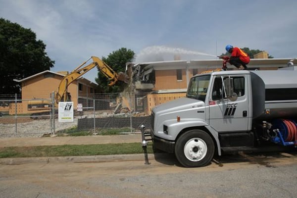 Bowen Homes is no more. The Atlanta Housing Authority began bulldozing the housing project Wednesday. James Riley sprays water to keep the dust down. (Courtesy of Johnny Crawford)