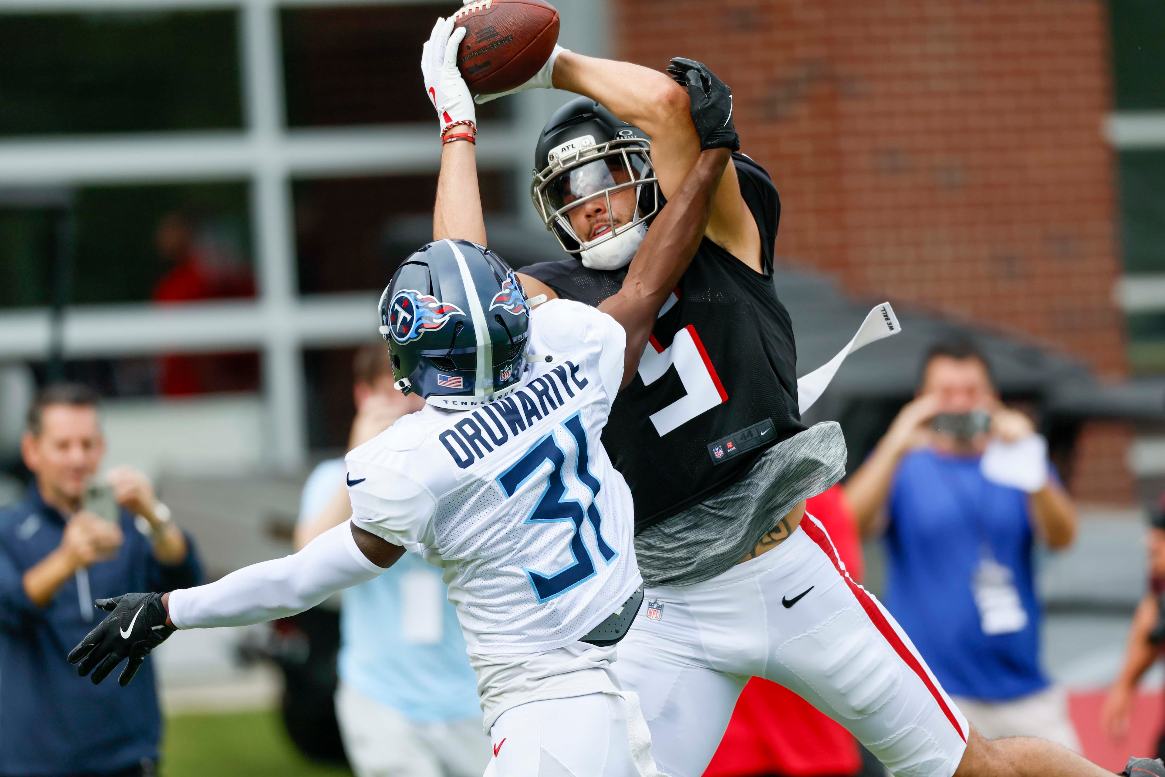 Falcons wide receiver Drake London (right), here making a catch in a joint practice against the Titans on Aug. 12, is signed through the 2026 season. (Miguel Martinez / AJC)