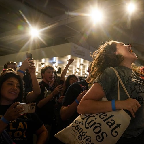 Nikita Valdez jumps while cheering after the first report of the election results show Democratic congressional candidate Melat Kiros in the lead during a primary election night watch party at The Broadway, Tuesday, June 30, 2026, in Denver. (AP Photo/Rebecca Slezak)