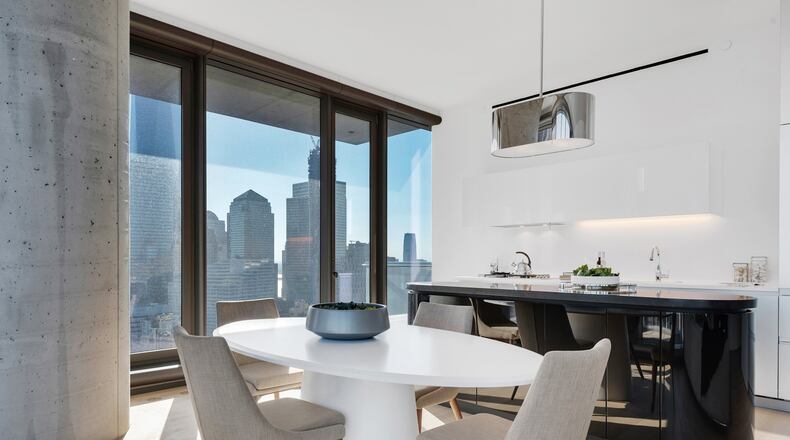 An oval-shaped dining table helps anchor this modern dining space. (Design Recipes)