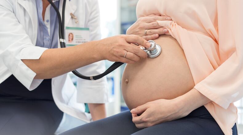 A doctor meets with a pregnant woman
