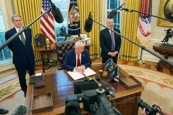 President Donald Trump speaks as Treasury Secretary Scott Bessent, left, and Commerce Secretary nominee Howard Lutnick listen as Trump prepares to sign an executive order in the Oval Office of the White House, Monday, Feb. 3, 2025, in Washington. (AP Photo/Evan Vucci)