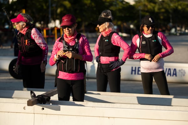 The Rosas Va'a Hawaiian canoeing team, whose members are women who have undergone cancer treatment, gather on Charitas Beach to train on the water in Niteroi, Rio de Janeiro state, Thursday, June 26, 2025. (AP Photo/Bruna Prado)