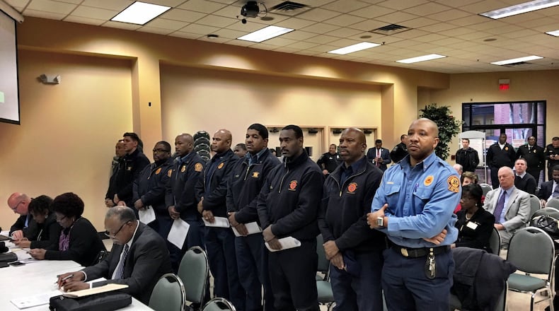 Firefighters stand together as they seek pay increases during the DeKalb County Board of Commissioners meeting Tuesday. County commissioners are also asking for a pay raise for themselves. MARK NIESSE / MARK.NIESSE@AJC.COM