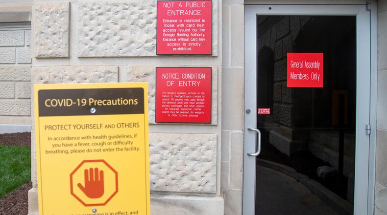 A sign warning visitors with COVID-19 symptoms to stay out of the Georgia State Capitol building is displayed near the entrance for legislatures in downtown Atlanta, Thursday, Jan. 7, 2021. (Alyssa Pointer / Alyssa.Pointer@ajc.com)