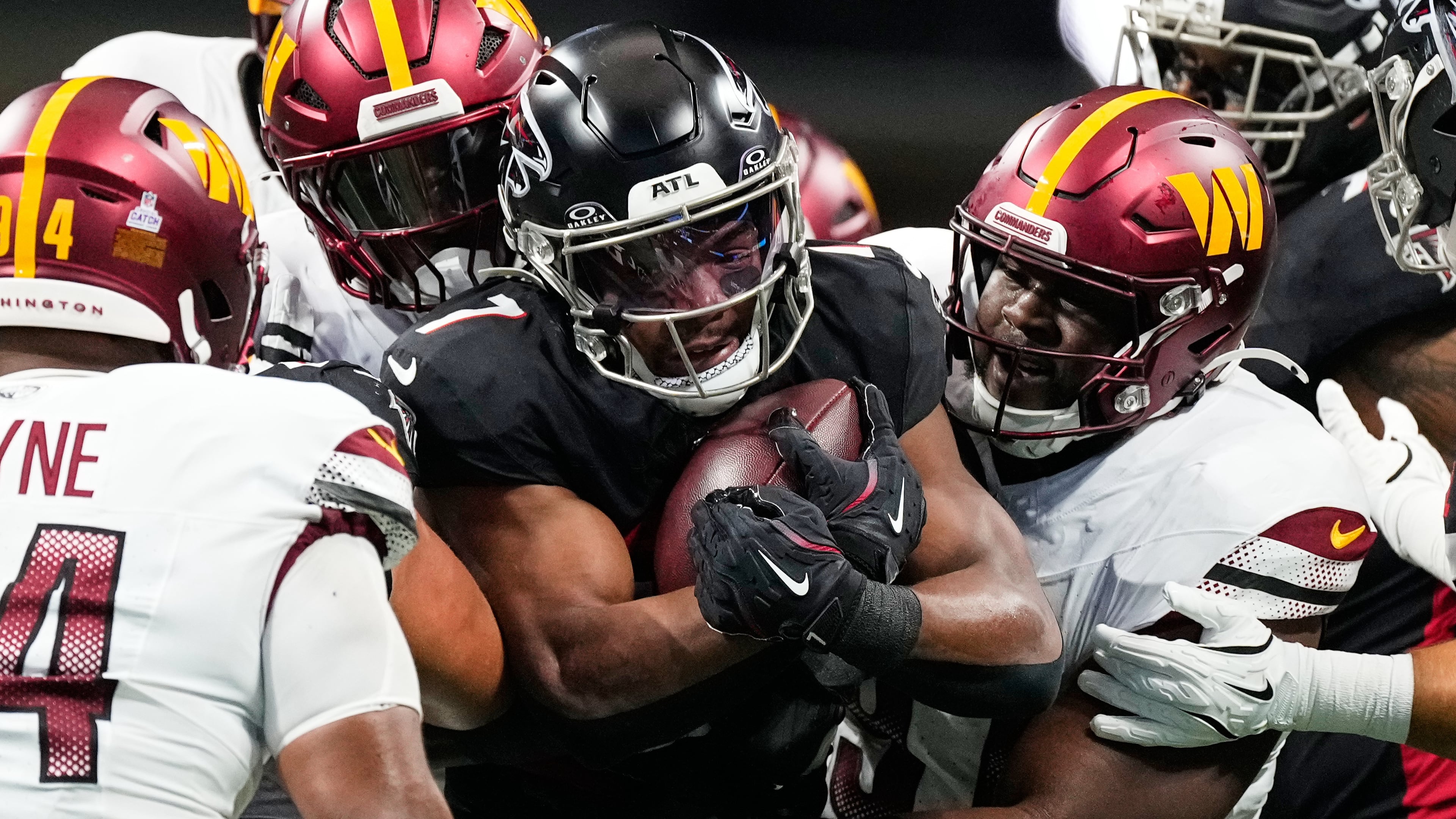 Atlanta Falcons running back Bijan Robinson, center, is tackled by Washington Commanders defenders during the first half of an NFL football game, Sunday, Sept. 28, 2025, in Atlanta. (AP Photo/Brynn Anderson)