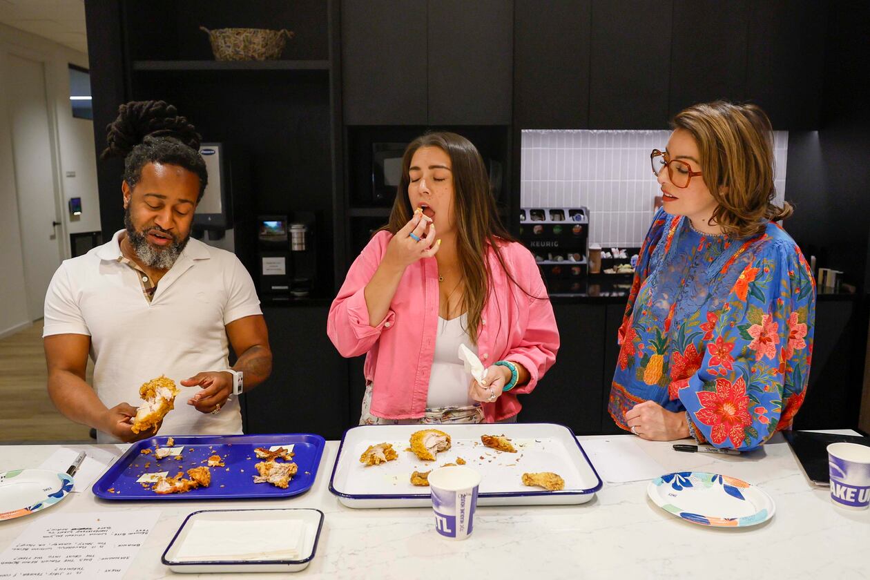 Daniela Cintron, editor at Discover Atlanta, center, reacts as she tastes a piece of fried chicken alongside Justin Brown, ATL50 expert panelist, during a contest to find Atlanta’s best fried chicken, held on Tuesday, Aug. 25, 2026, at the AJC office in Midtown. (Miguel Martinez/AJC)