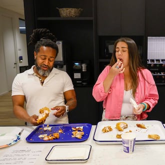 Daniela Cintron, editor at Discover Atlanta, center, reacts as she tastes a piece of fried chicken alongside Justin Brown, ATL50 expert panelist, during a contest to find Atlanta’s best fried chicken, held on Tuesday, Aug. 25, 2026, at the AJC office in Midtown. (Miguel Martinez/AJC)