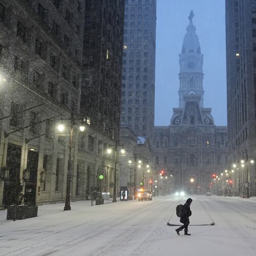 A person walks across a street during a winter storm in Philadelphia, Sunday, Jan. 25, 2026. (AP Photo/Matt Rourke)