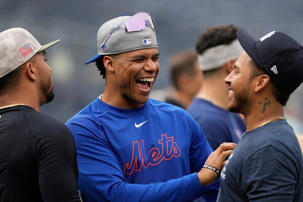 New York Mets' Juan Soto, center, talks with New York Yankees' Jorbit Vivas before a baseball game Friday, May 16, 2025, in New York. (AP Photo/Seth Wenig)