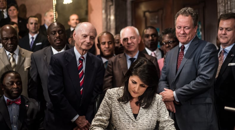 COLUMBIA, SC - JULY 9: South Carolina Gov. Nikki Haley signs a bill to remove the Confederate battle flag from the state house grounds July 9, 2015 in Columbia, South Carolina. Debate on the flag was reignited three weeks ago after the mass murder at Emanuel AME Church in Charleston, South Carolina. (Photo by Sean Rayford/Getty Images)