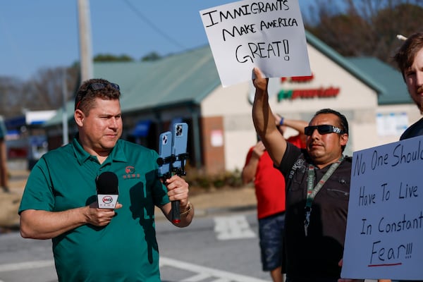 Mario Guevara covers a protest against immigration enforcement on Buford Highway on Saturday, Feb. 1, 2025. (Miguel Martinez/AJC)