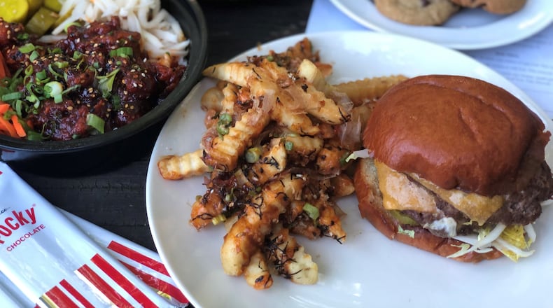 A Whiskey Bird burger, plated at home, came with okonomiyaki fries. In the back: the Korean fried chicken bowl, Little Bird Caesar and a half-dozen chocolate-chip cookies. CONTRIBUTED BY WENDELL BROCK