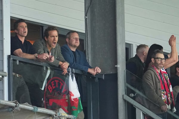 Wrexham co-owners Rob McElhenney, left, and Ryan Reynolds, second left, react during the English League One soccer match between Wrexham and Charlton Athletic at the Racecourse ground in Wrexham, Wales, Saturday, April 26, 2025. (AP Photo/Jon Super)