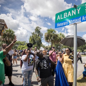 BRUNSWICK, GA - AUGUST, 9, 2022: Ahmaud Arbery's father, Marcus Arbery, and his mother Wanda Cooper-Jones, look on as city officials unveil a street sign commemorating their slain son. (AJC Photo/Stephen B. Morton)