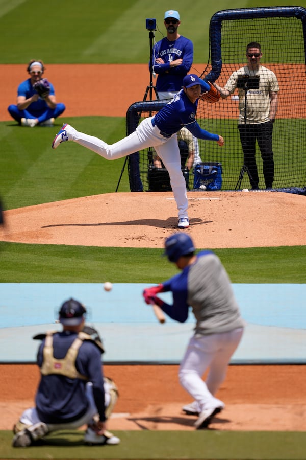 Los Angeles Dodgers' pitcher Shohei Ohtani, center, throws live batting practice as pitching coach Mark Prior, top, watches prior to a baseball game against the New York Yankees, Saturday, May 31, 2025, in Los Angeles. (AP Photo/Mark J. Terrill)