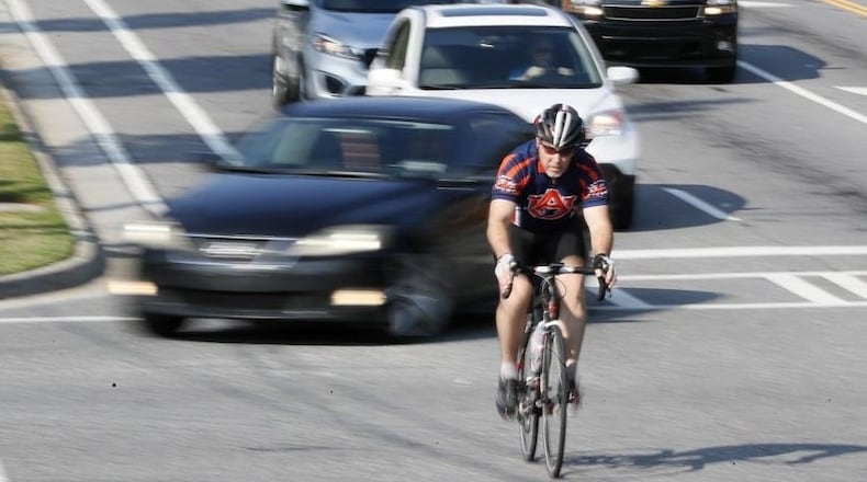 A cyclist crosses the Mt. Vernon and Chamblee Dunwoody Road intersection in Dunwoody, where city leaders are considering instituting a “Vulnerable Road User” ordinance. It would give additional protection to people deemed “vulnerable” on the road, like pedestrians and cyclists. (Bob Andres / robert.andres@ajc.com)