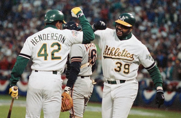 FILE - Oakland Athletics Dave Henderson (42) greets teammate Dave Parker (39) after Parker hit a home run against the San Francisco Giants in the third inning in Game 1 of baseball's World Series, Oct. 14, 1989, in Oakland, Calif. (AP Photo/Lenny Ignelzi, File)