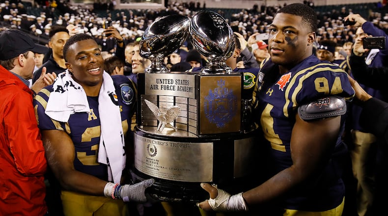 Navy midshipmen carrie off the Commander in Chief's trophy after defeating Army in an NCAA college football game, Saturday, Dec. 14, 2019, in Philadelphia. Navy won 31-7. (AP Photo/Matt Rourke)