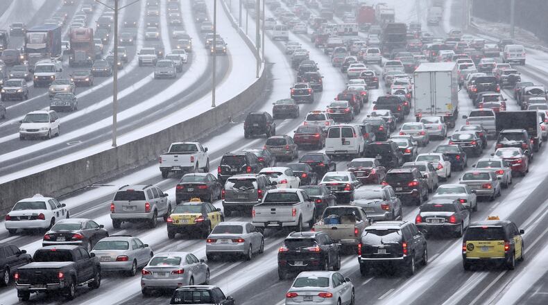 Traffic inches along the Connector as snow blankets the Metro on Tuesday afternoon January 28, 2014 as seen from the Pryor Street overpass. BEN GRAY / AJC File Photo