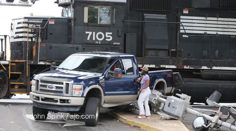 Shakira Stokes retrieves her father's belongings after a Norfolk Southern train hit his truck on Lee Street near Sylvan Road. JOHN SPINK / JSPINK@AJC.COM