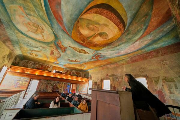 Veronique Plesch, an art professor at Colby College, gives a lecture to art teachers about the frescoes that adorn the walls and ceiling of the South Solon Meeting House, Sunday, April 6, 2025, in Solon, Maine. (AP Photo/Robert F. Bukaty)