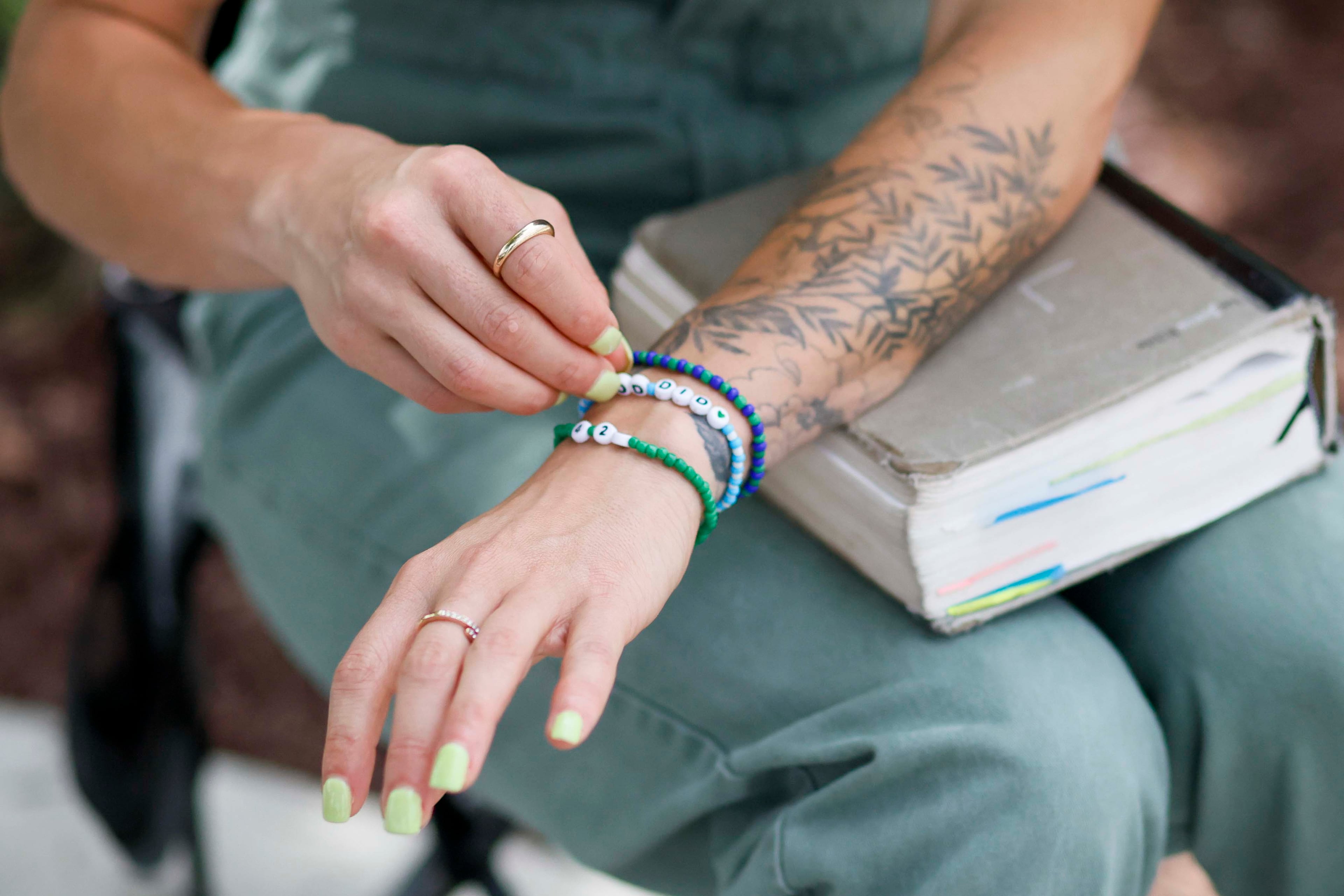 Hayle Swinson, a former student and staff member at Truett McConnell University, displays her bracelets, which symbolize her journey to healing that, together with her Bible, helped her continue moving forward after she accused a former vice president of the school of sexual abuse. (Miguel Martinez/AJC)