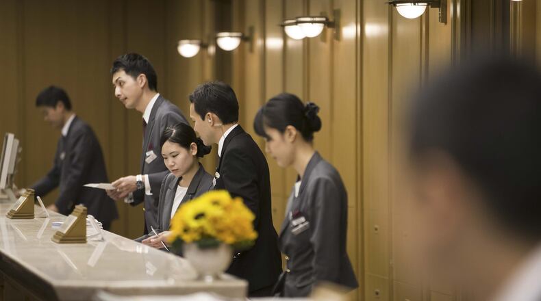 Employees at the reception area at the lobby of the Imperial Hotel in Tokyo on Aug. 19, 2016. Bloomberg photo by Tomohiro Ohsumi.