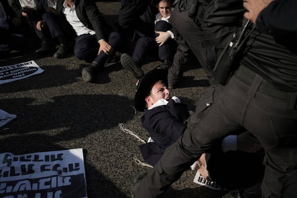 Israeli police officers disperse ultra-Orthodox Jewish men during a protest against army recruitment in Bnei Brak, Israel, Thursday, June 5, 2025. (AP Photo/Leo Correa)
